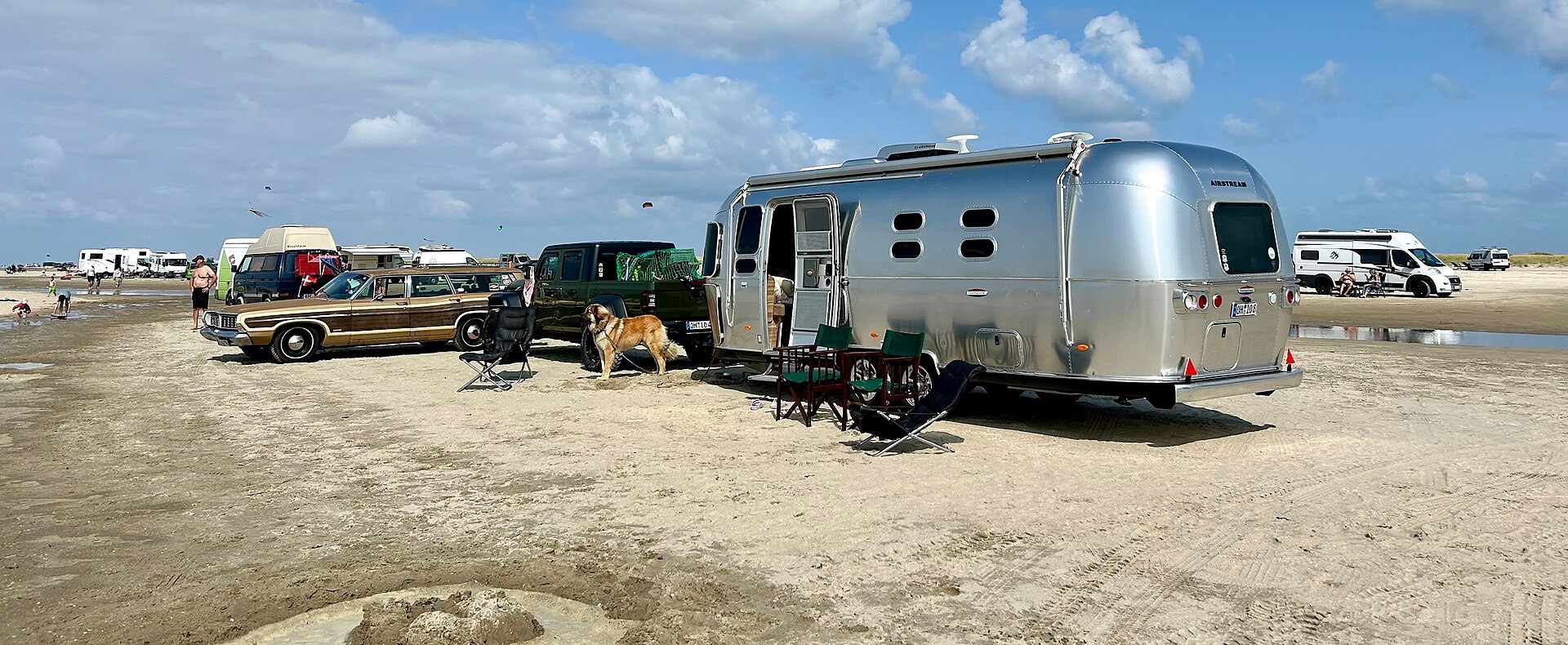 A travel trailer parked level on a beach.